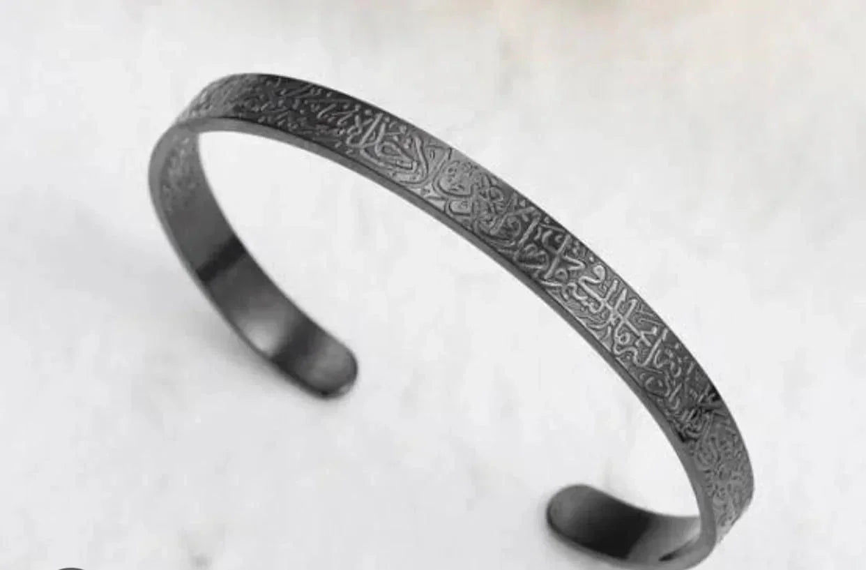 Ayatul Kursi engraved black cuff bracelet on marble background, Arabella Vibe jewelry